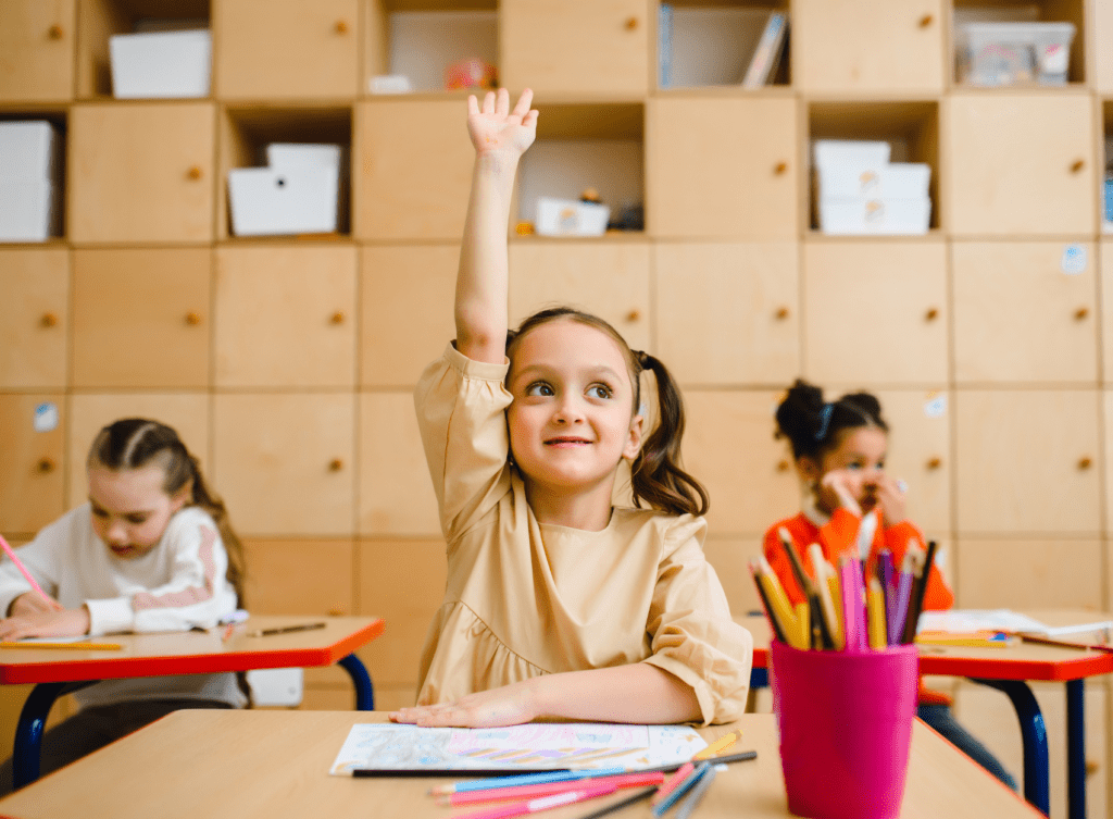 Little girl raising hand in class